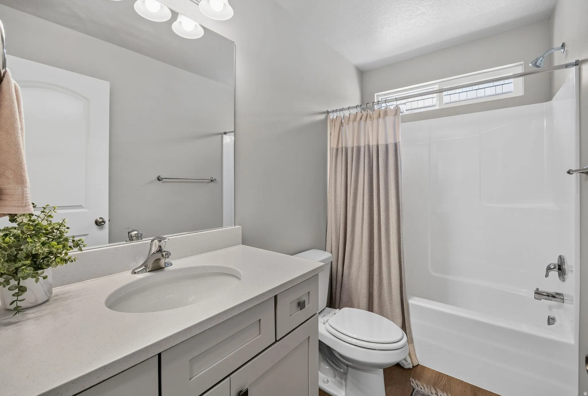 Bathroom featuring a single vanity with light-toned countertop, integrated sink, and chrome fixtures