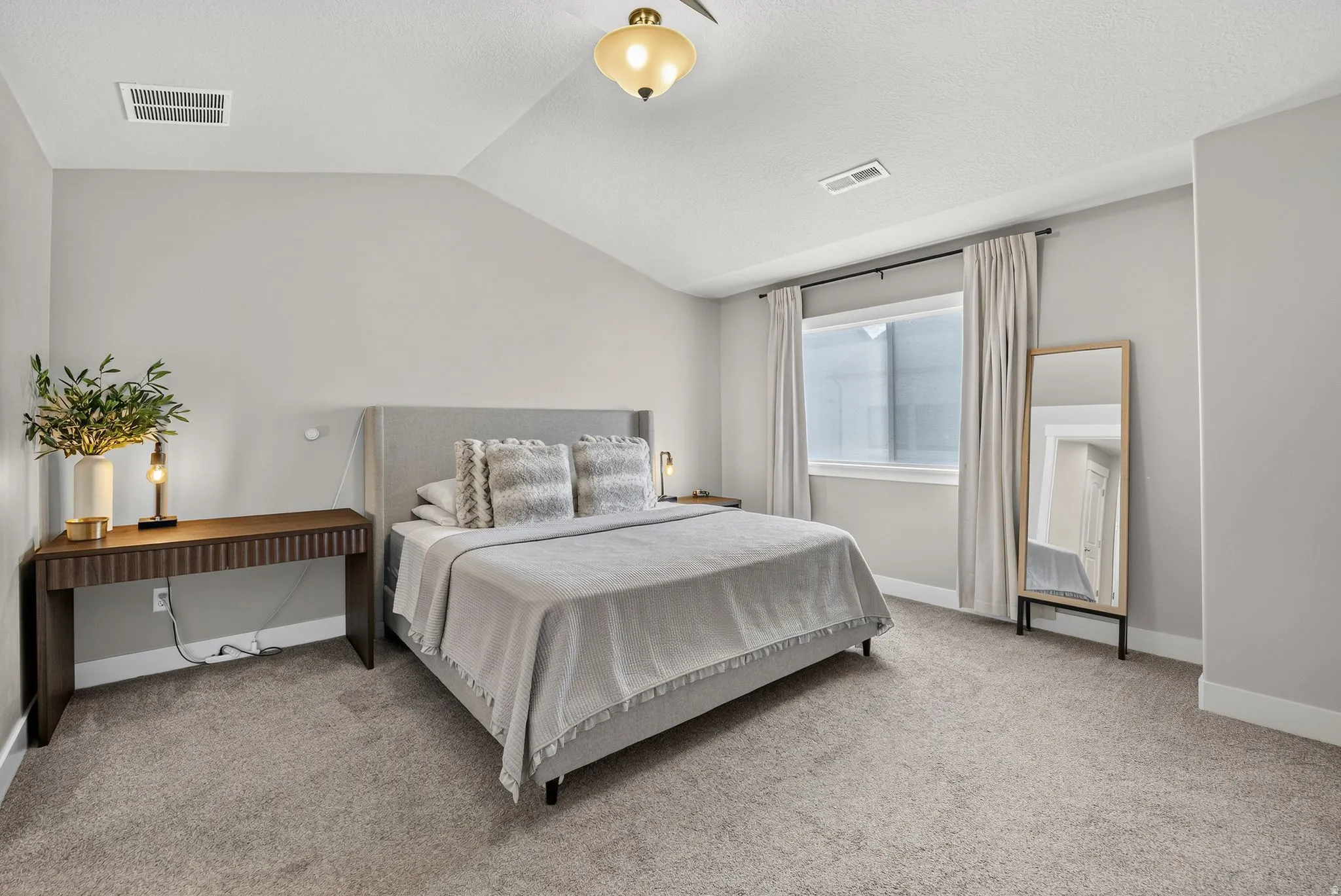 Tray ceiling, recessed lighting, carpet flooring, window with drapes, and a built-in wall light