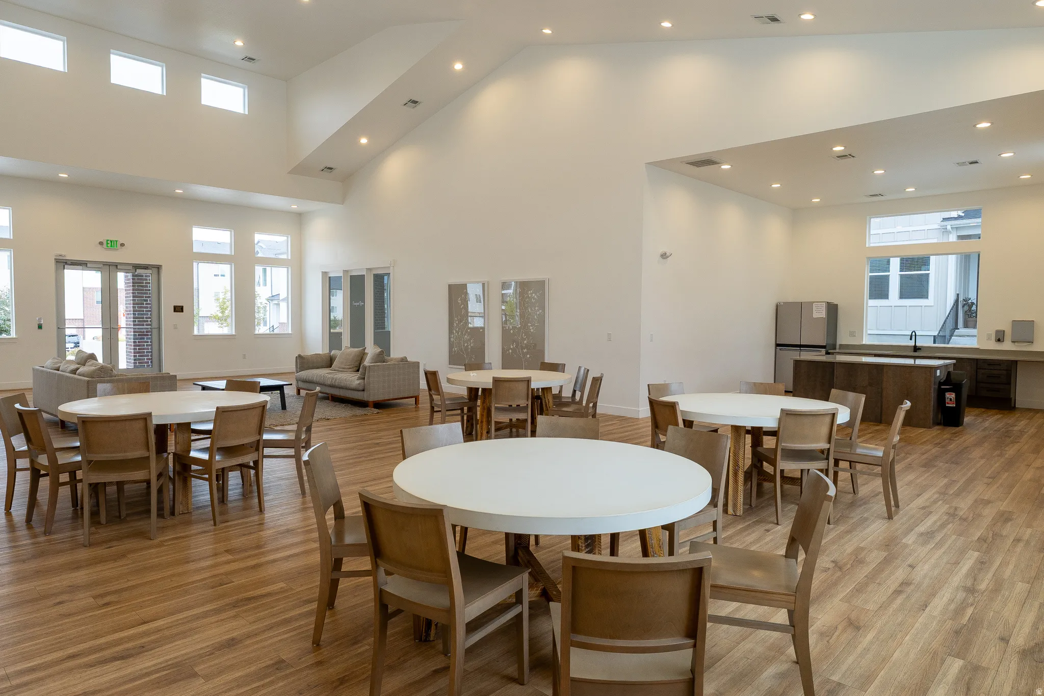 Vaulted ceilings, wood-finish flooring, recessed lighting, and multiple large windows