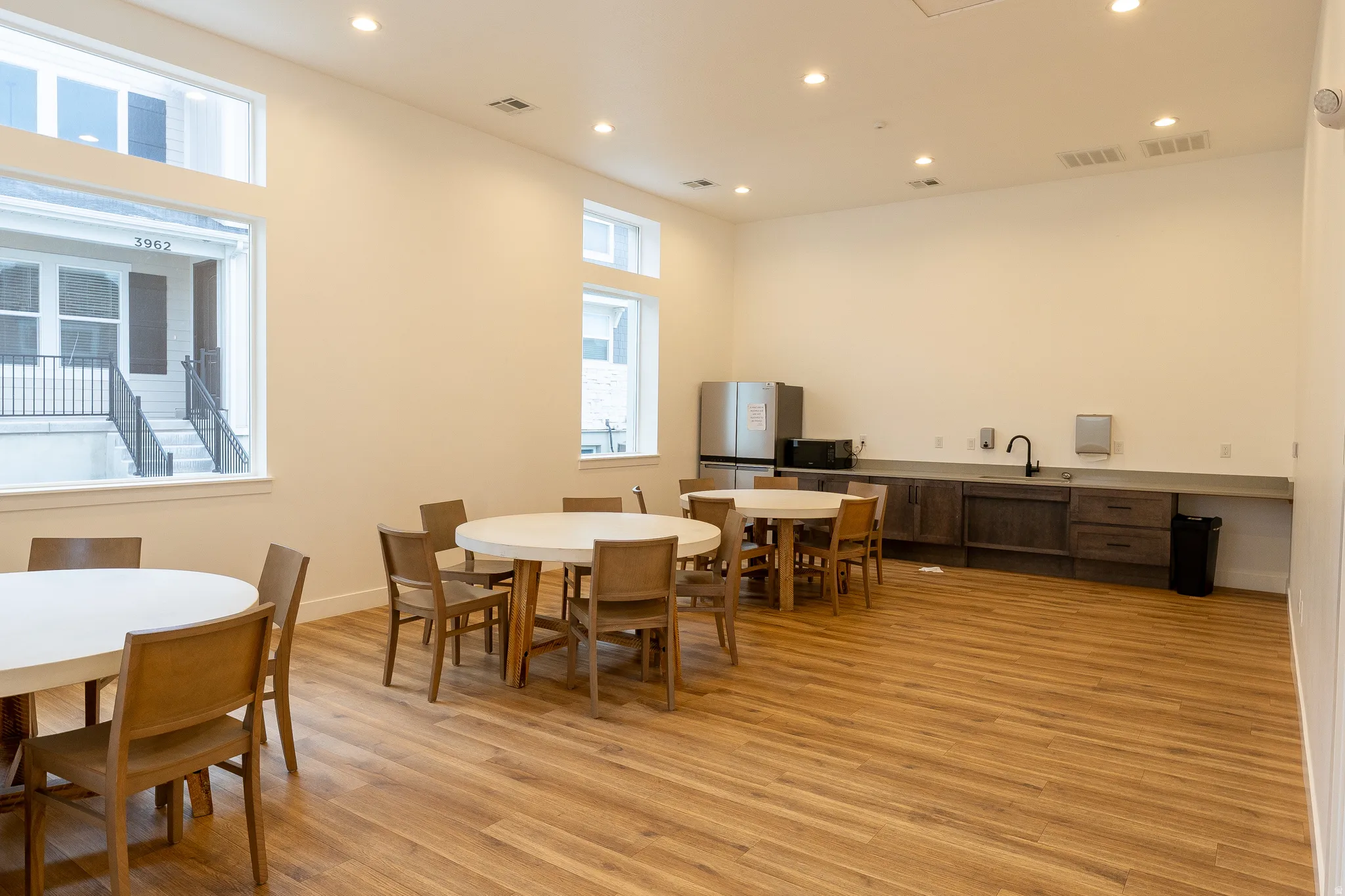 High ceilings with recessed lighting, wood-finish flooring, and multiple windows