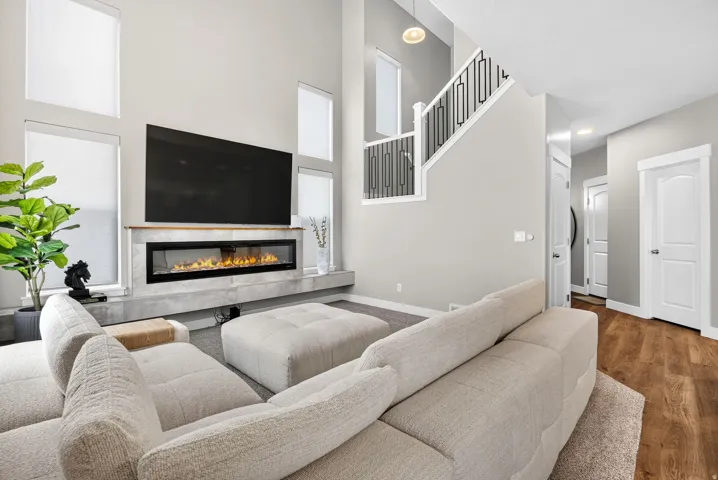 Vaulted ceiling with an integrated linear fireplace, a floating mantel, and multiple tall windows