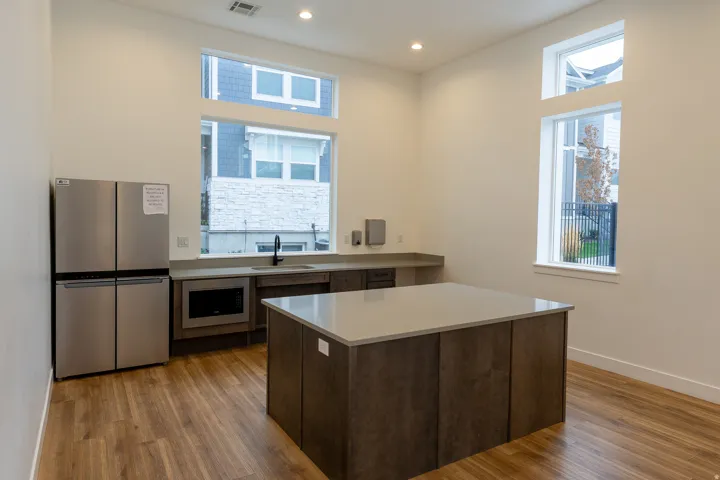 Wood-finish flooring, recessed lighting, and a stainless steel refrigerator