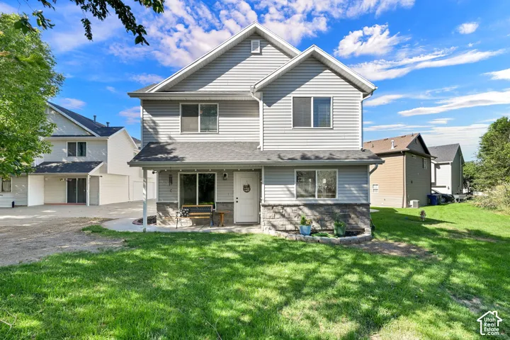 Two-story home featuring a clean, modern exterior with gray vinyl siding and a peaked roofline