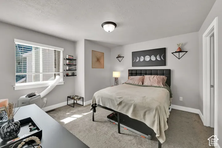 2nd Bedroom. Carpeted bedroom featuring a window with blinds, a ceiling-mounted light fixture, and a built-in closet with a bifold door
