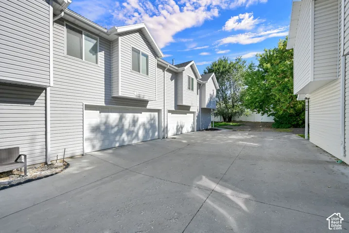 Light gray siding exterior with multiple garage bays and white garage doors