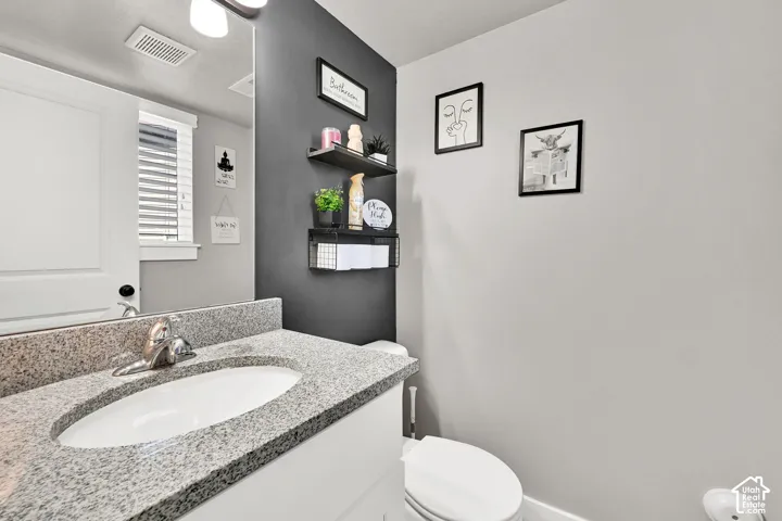 1/2 Bath down stairs on the main level. Vanity with a granite-style countertop and integrated oval sink