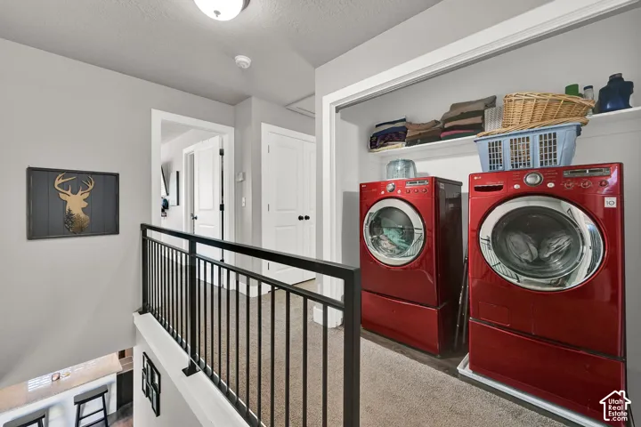 Dedicated laundry area featuring front-loading machines and integrated shelving