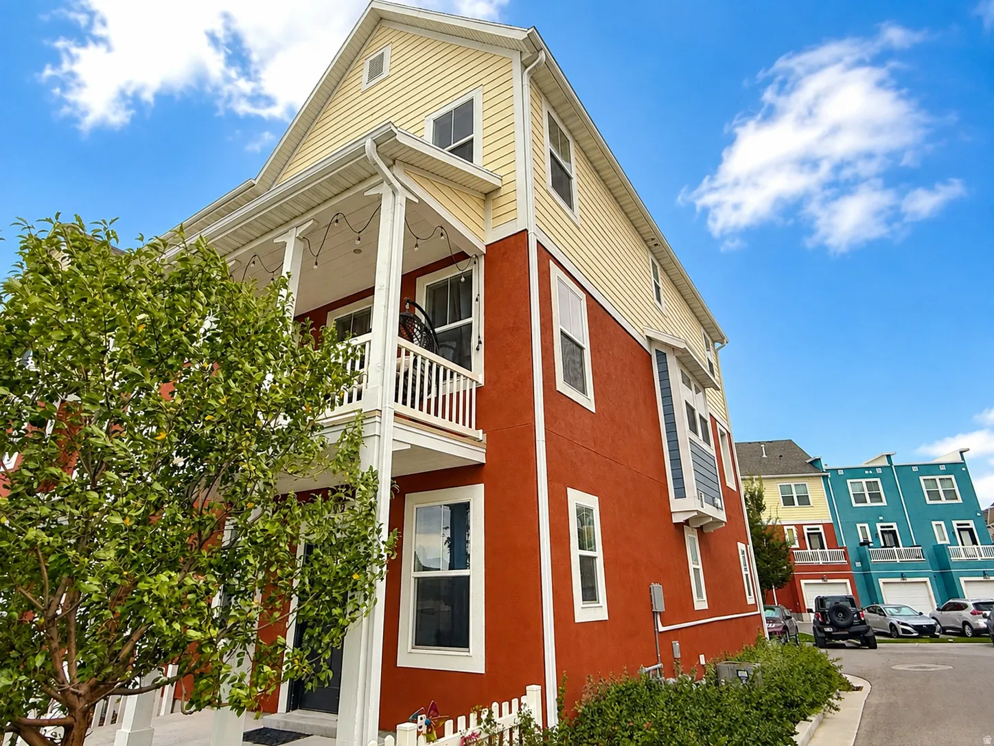Multi-story exterior with vibrant red stucco and yellow siding