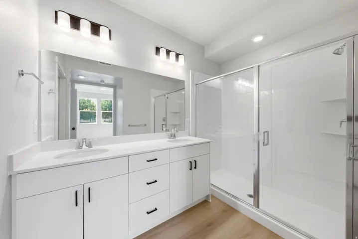 Dual vanity with white cabinetry, integrated sinks, and quartz countertops