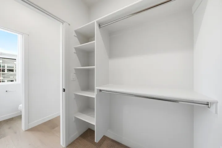 Built-in closet system with multiple shelving units and hanging rods