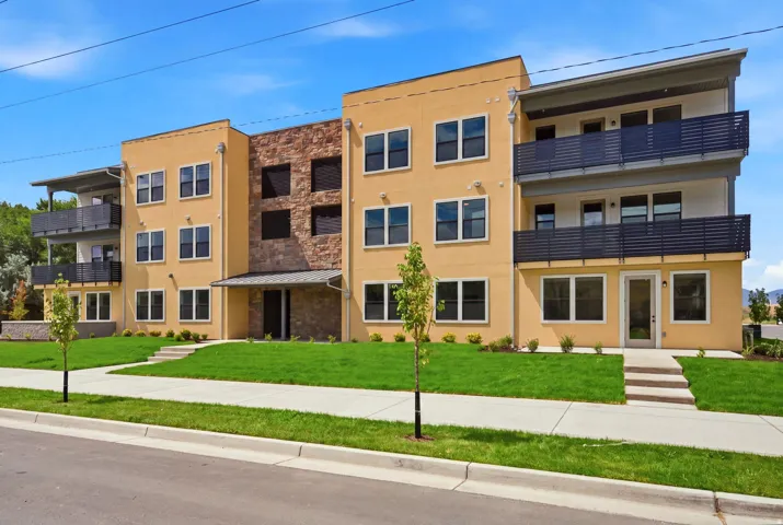 Contemporary multi-story facade featuring stucco and stone veneer accents