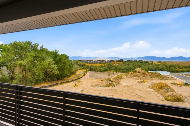 Balcony with slatted railing, providing expansive outdoor scenery and distant mountain range