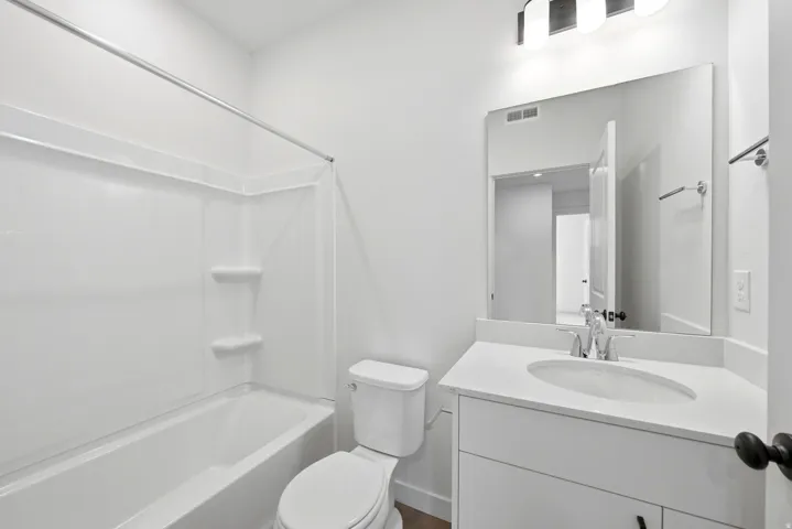 White vanity with integrated sink, chrome faucet, and quartz countertop