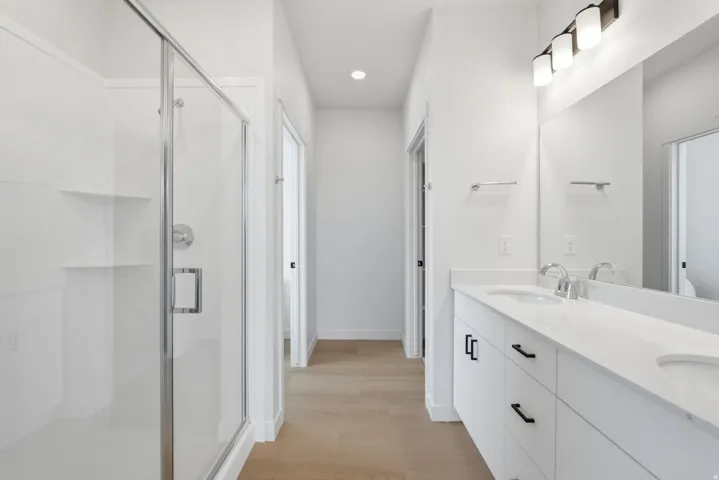 Dual sink vanity with white countertops, chrome faucets, and matte black hardware