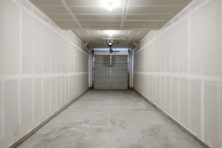 Enclosed garage space with concrete flooring and a roll-up garage door
