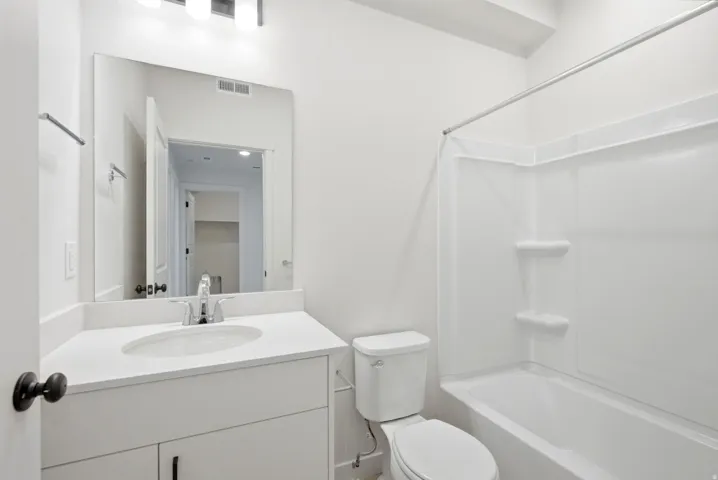 Bathroom featuring a full vanity with an integrated sink, polished chrome faucet, and a large mirror