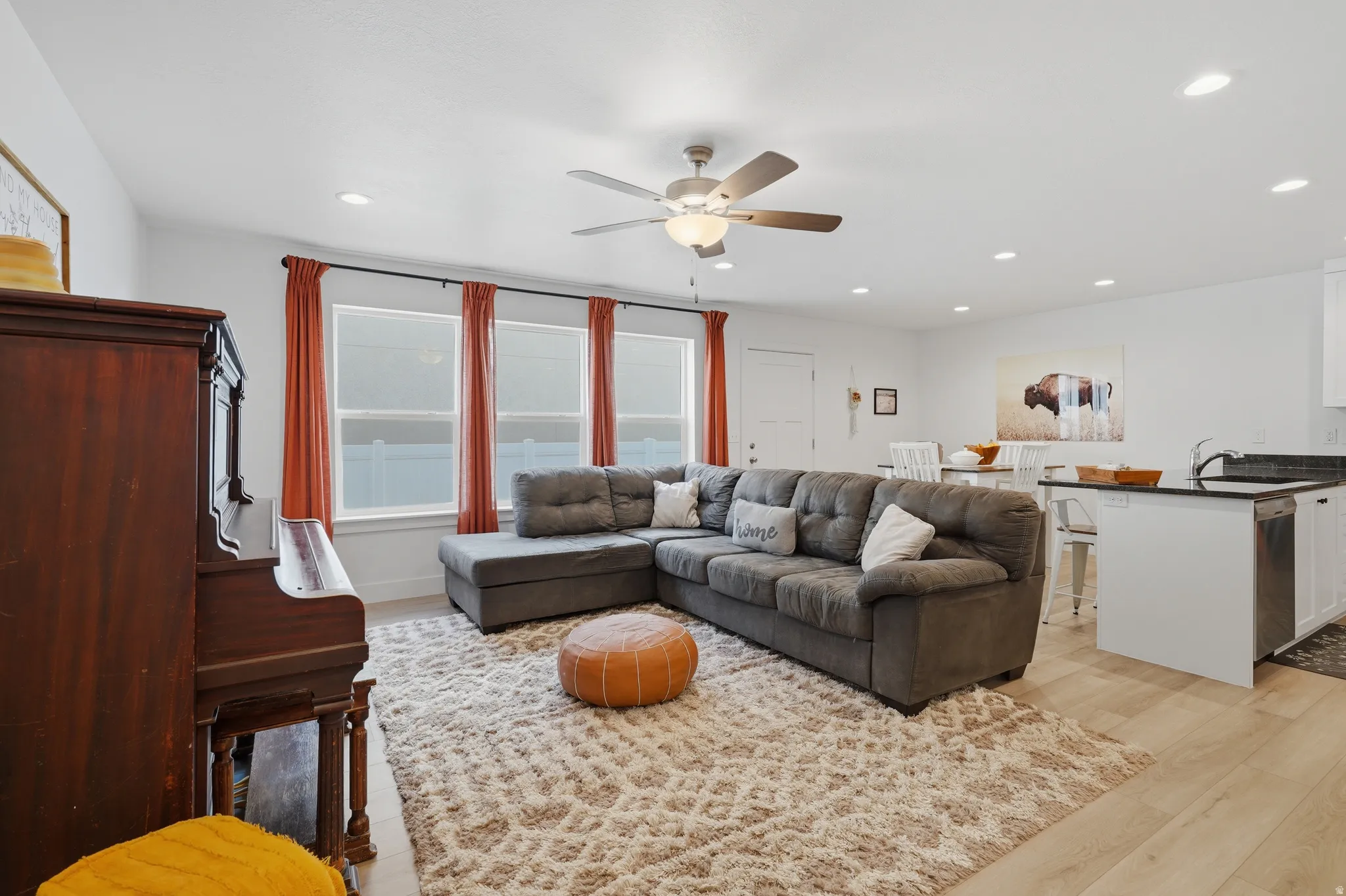 Open-concept living space featuring wood-finish flooring, recessed lighting, and a ceiling fan