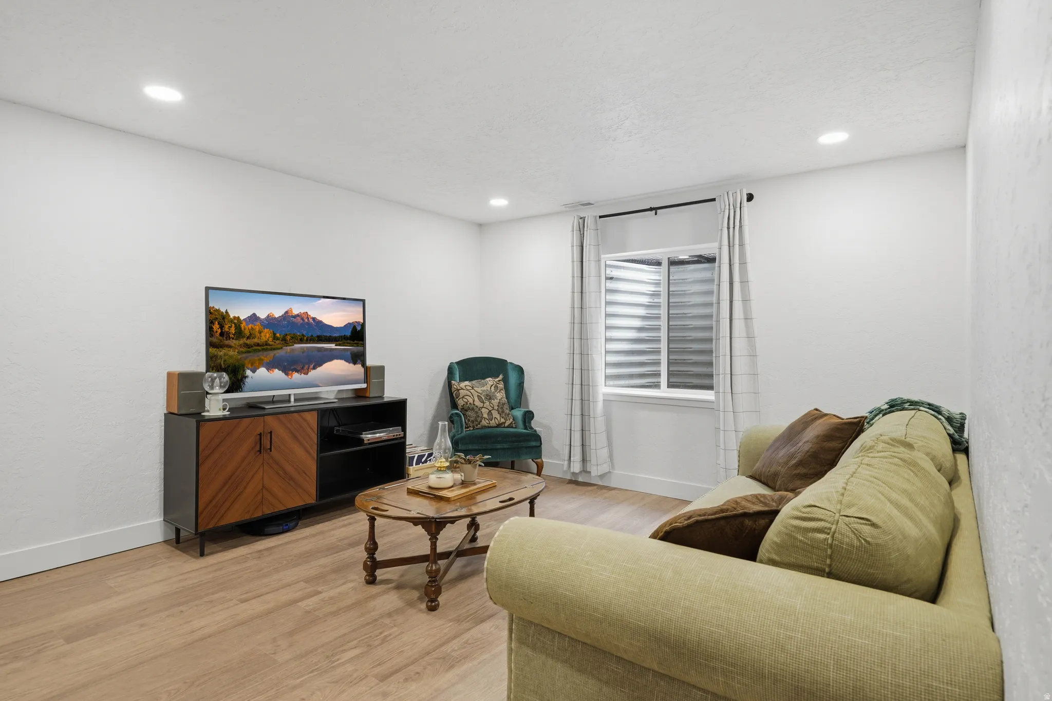 Recessed lighting, wood-finish flooring, white walls, and a window with horizontal blinds