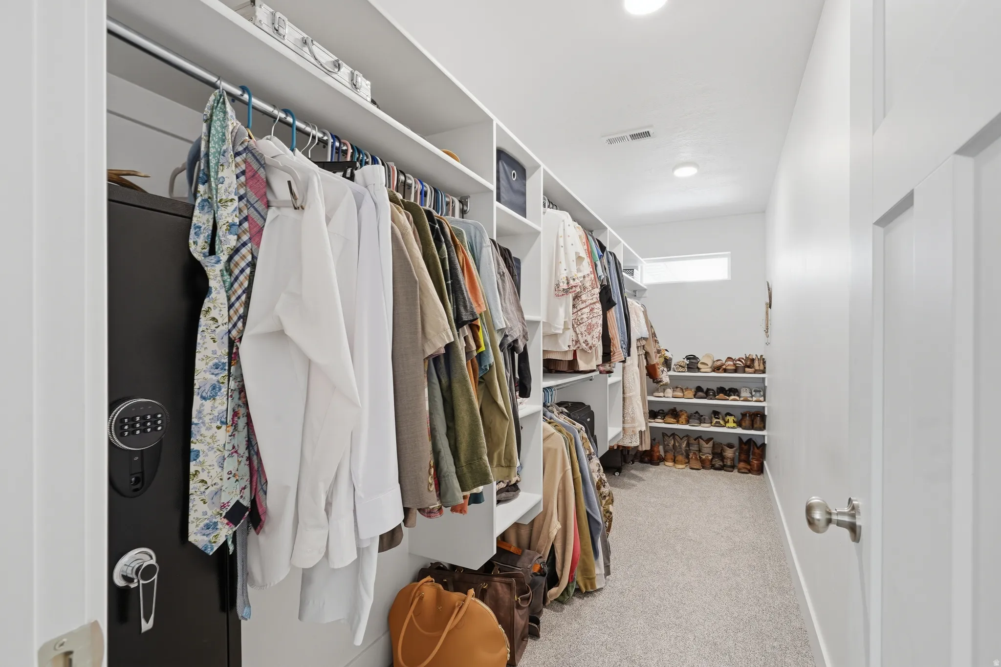 Walk-in closet featuring built-in shelving, hanging rods, and recessed lighting