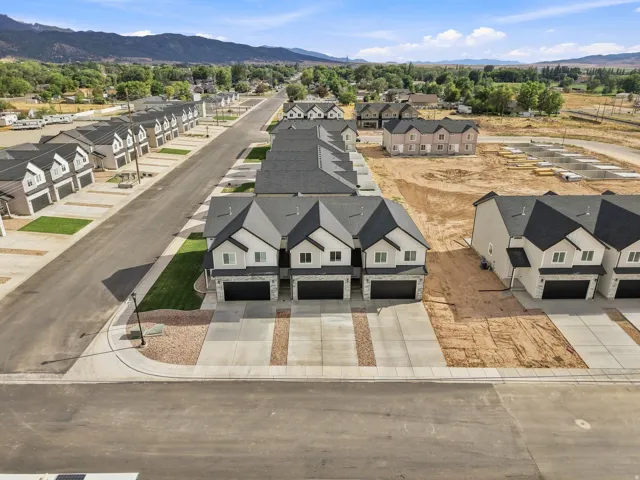 Contemporary townhomes featuring dark asphalt shingle roofs and light-colored siding