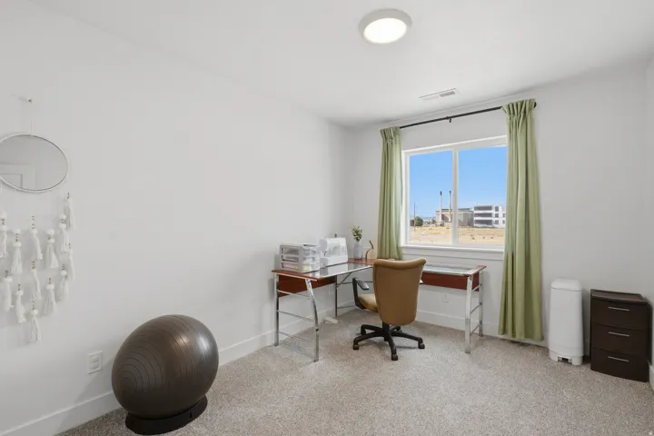 Recessed lighting, large window, and light-toned carpeting