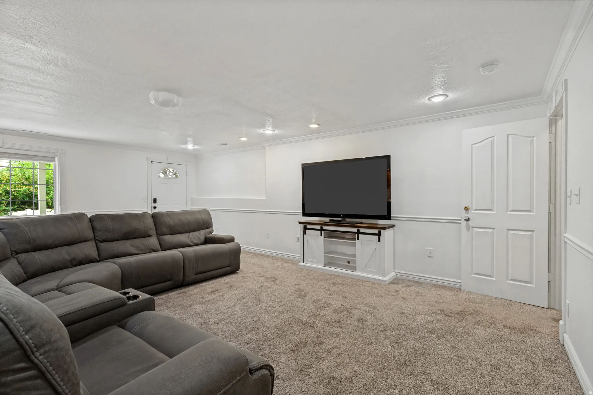Recessed lighting, crown molding, wainscoting, carpet flooring, and a window with exterior visibility