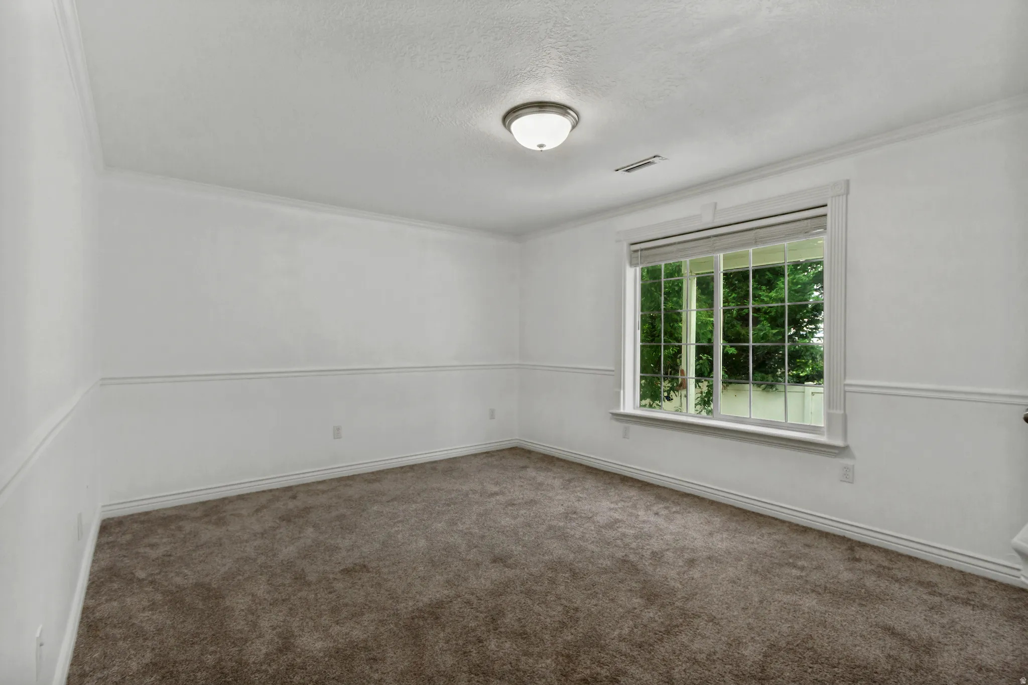 Recessed window with white trim, wall paneling, crown molding, and a flush mount ceiling light