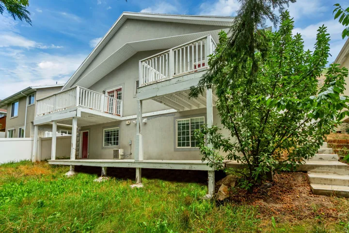 Exterior featuring a two-story deck, ground-level patio, and concrete staircase