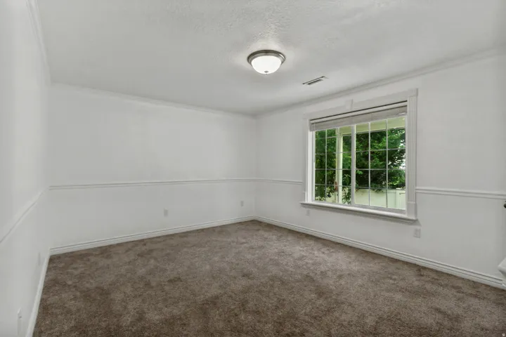 Recessed window with white trim, wall paneling, crown molding, and a flush mount ceiling light