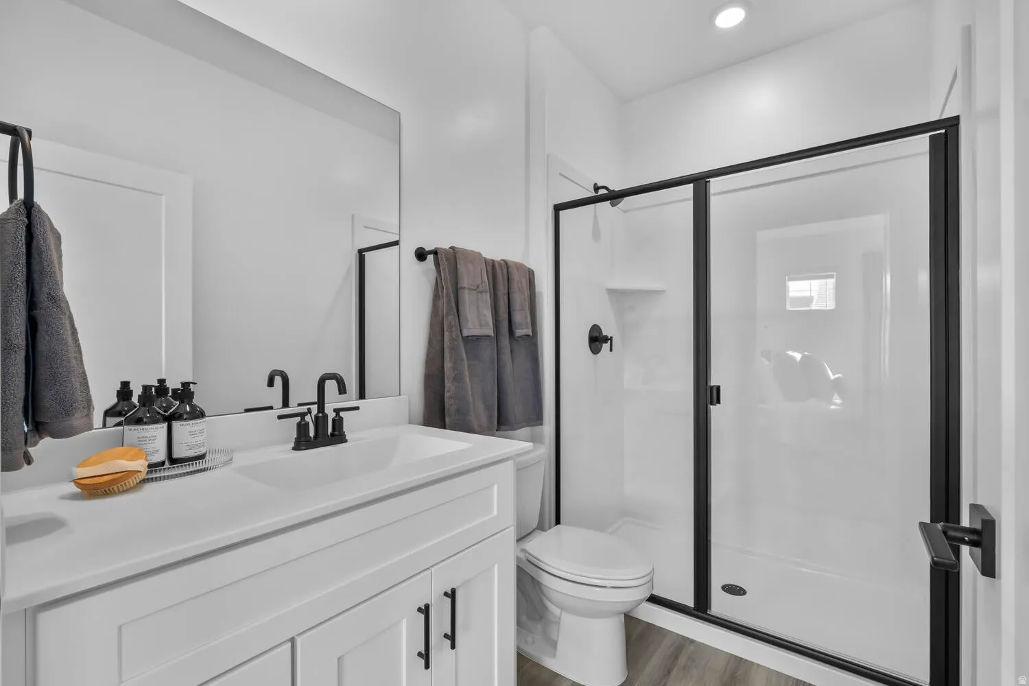White vanity with black hardware, rectangular sink, and matte black faucet