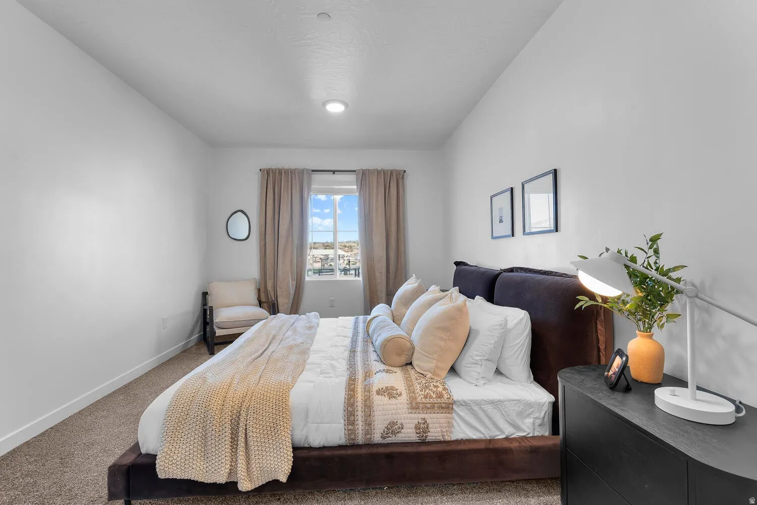 Recessed ceiling lighting, textured wall finishes, carpeted flooring, window with drapes, and a dark wood-finish dresser