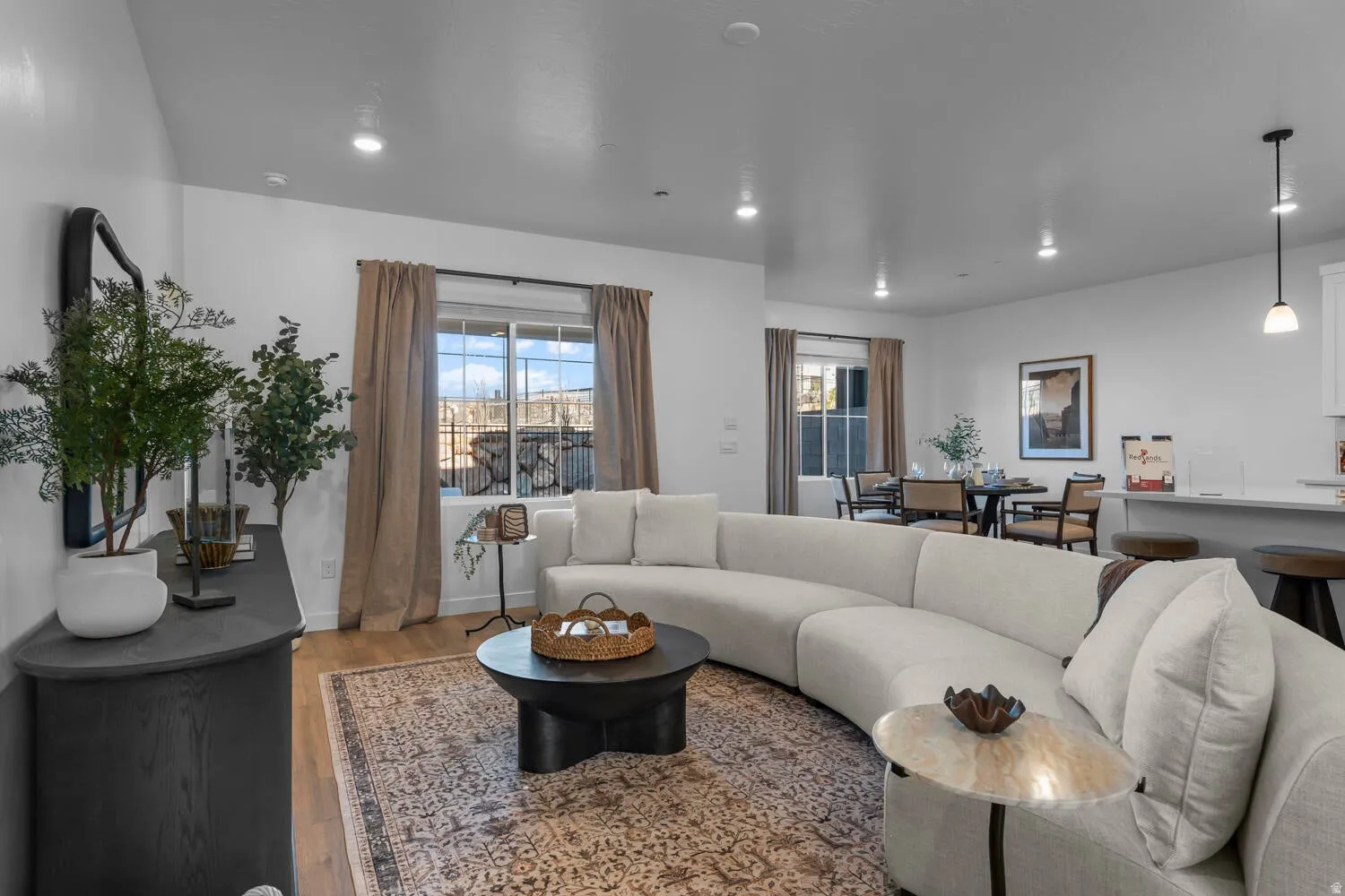 Open-concept living area featuring recessed lighting, wood-finish flooring, and a large window