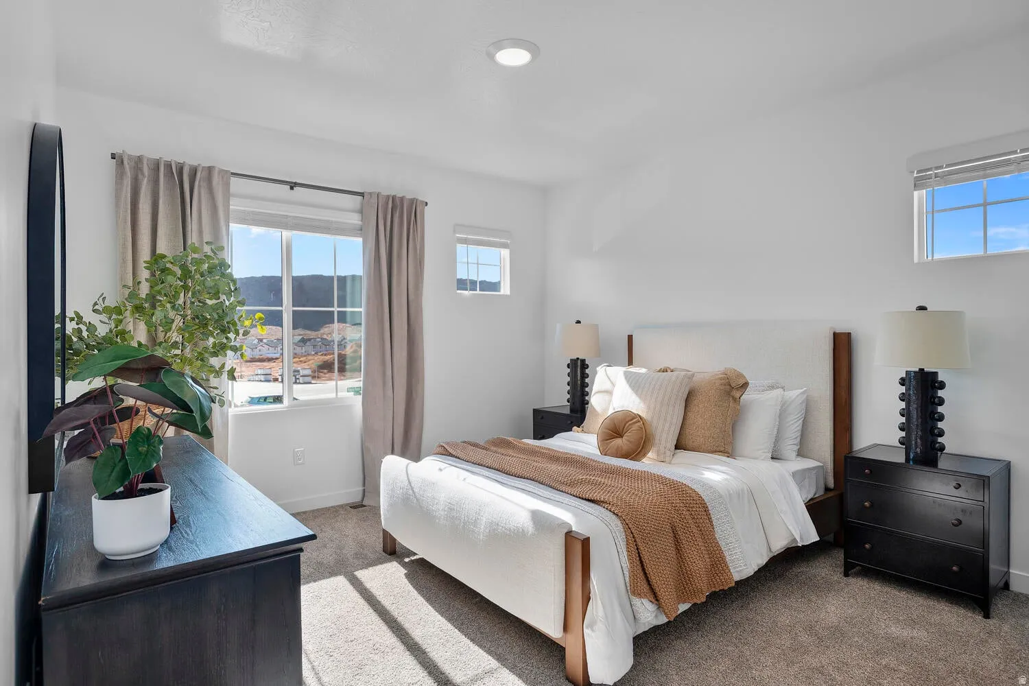 Bright room featuring a large window, a smaller transom window, recessed ceiling lighting, and neutral carpet flooring