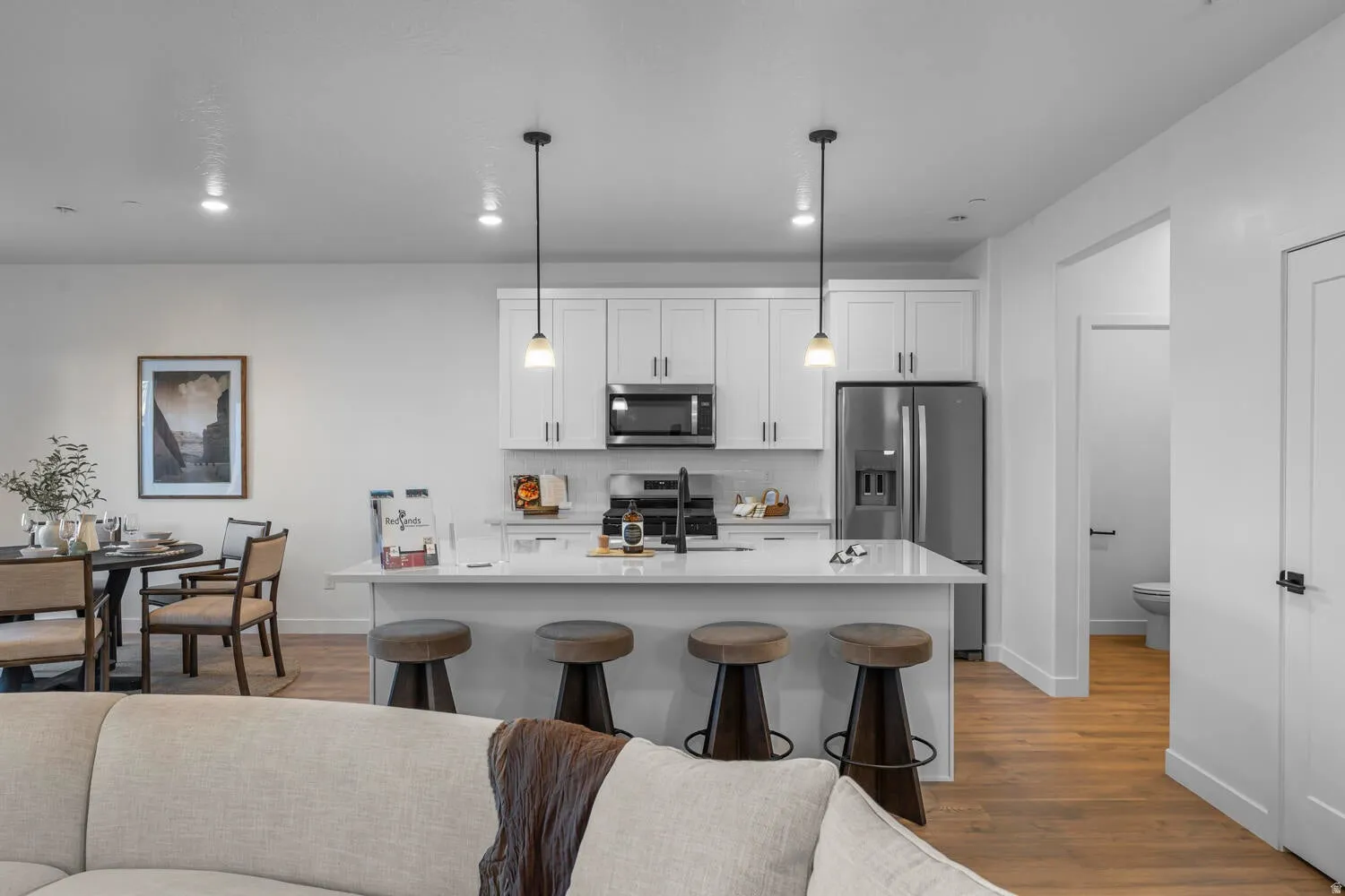 Kitchen with white cabinetry, stainless steel appliances, and a central island with pendant lighting