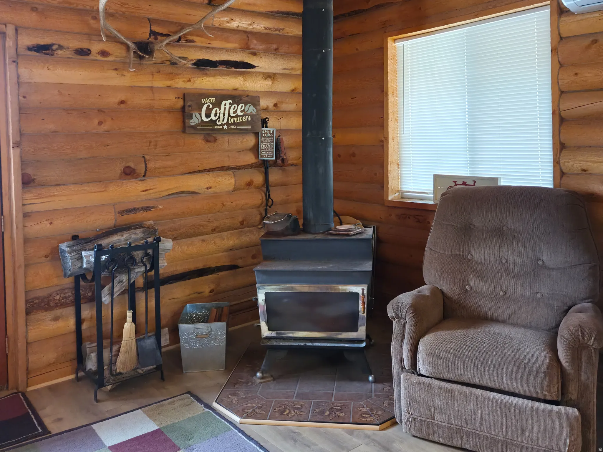 Exposed wood beam ceiling, log walls, and wood-finish flooring