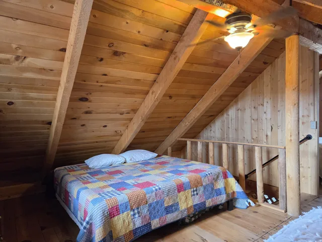 Wood-paneled sloped ceiling with exposed beams