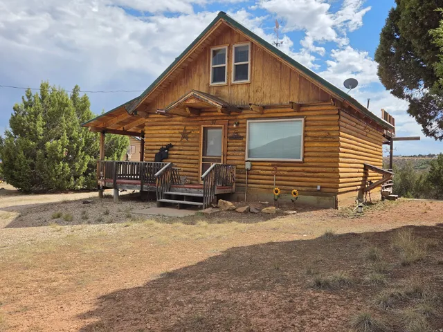 Log cabin exterior with an A-frame roof and covered front porch