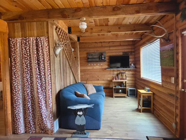 Wood-finish flooring, wood-paneled walls, exposed wood beams, and a wood staircase with lattice railing
