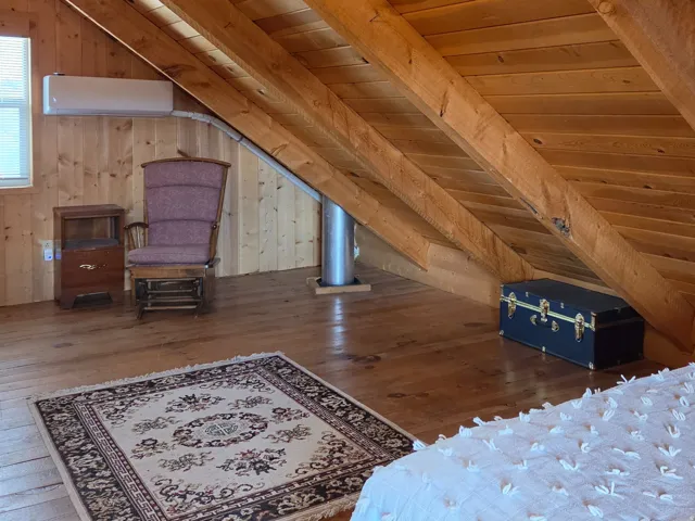 Exposed wood beam ceiling and wood plank walls with wood-finish flooring