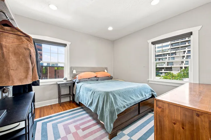 Hardwood flooring, recessed lighting, and large windows with privacy blinds