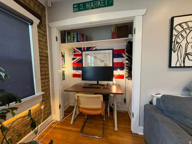 Built-in desk area with integrated shelving, hardwood flooring, and light gray wall paint