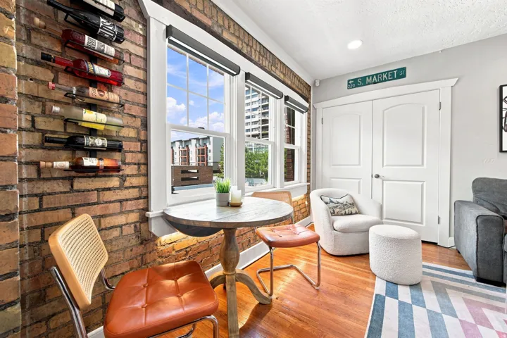 Exposed brick wall, hardwood flooring, white paneled doors, recessed lighting, and multiple windows