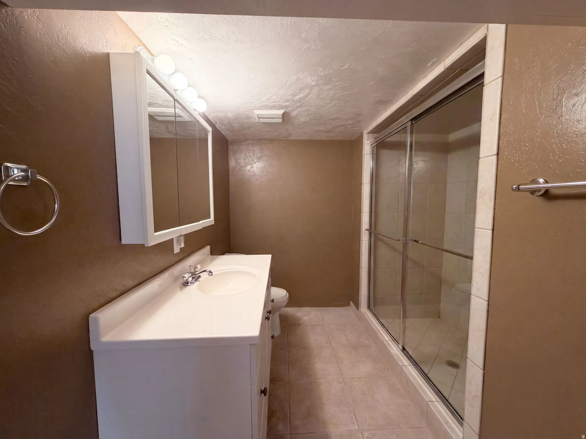 White vanity with integrated sink, chrome faucet, and mirrored medicine cabinet