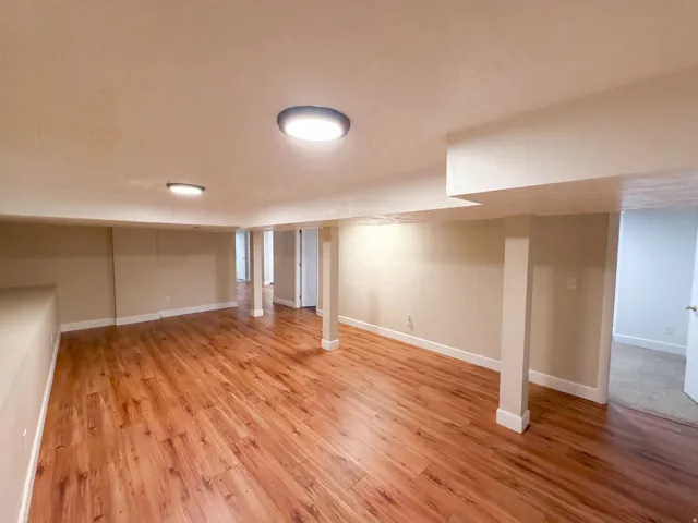 Expansive room featuring wood-finish flooring, recessed lighting, and neutral wall tones