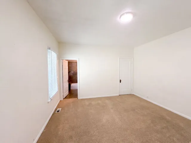 Neutral wall paint with carpet flooring, window with blinds, and ceiling-mounted light fixture