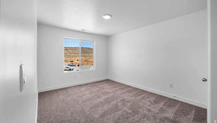 Recessed lighting, large window, carpet flooring, base molding, and a neutral wall palette