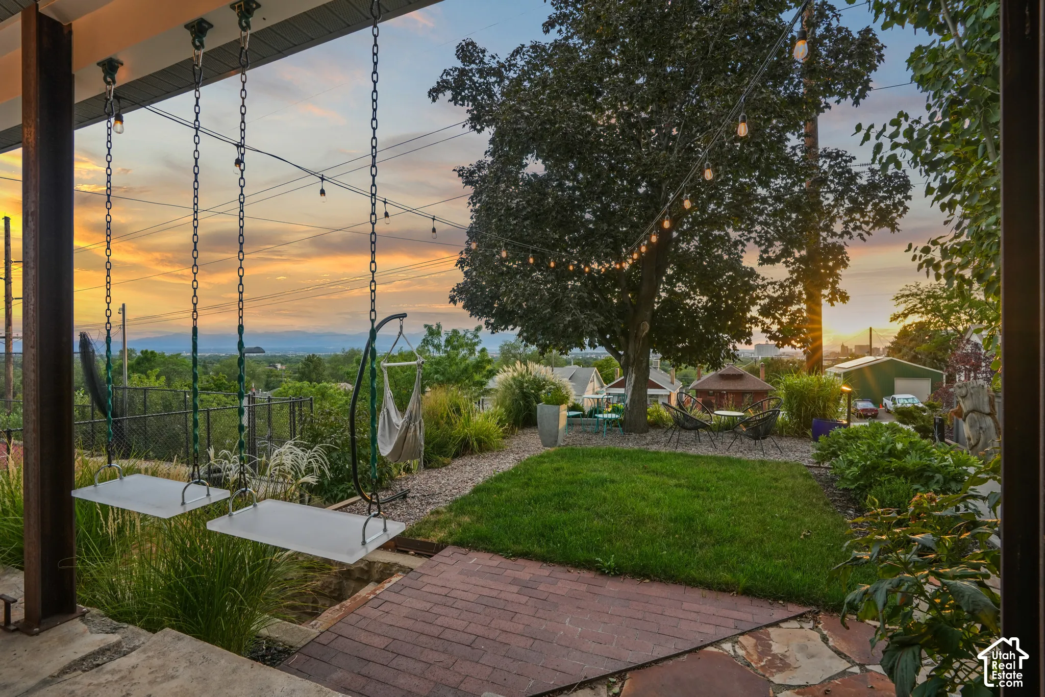 Expansive outdoor living area featuring a manicured lawn, flagstone patio, and mature trees