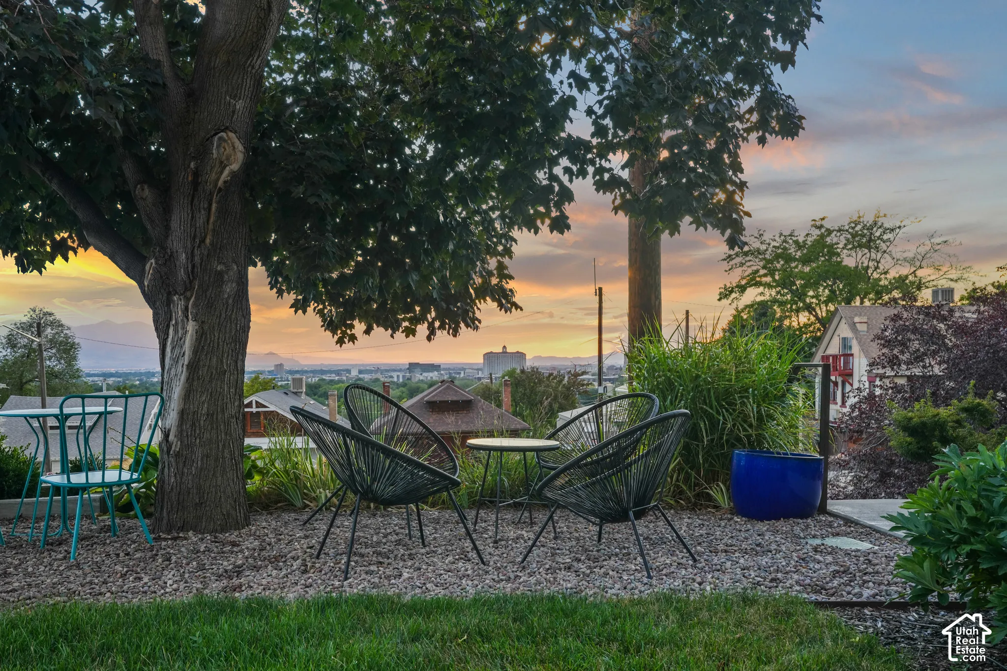 Tiered yard with established trees, gravel patio, and concrete stepping stones
