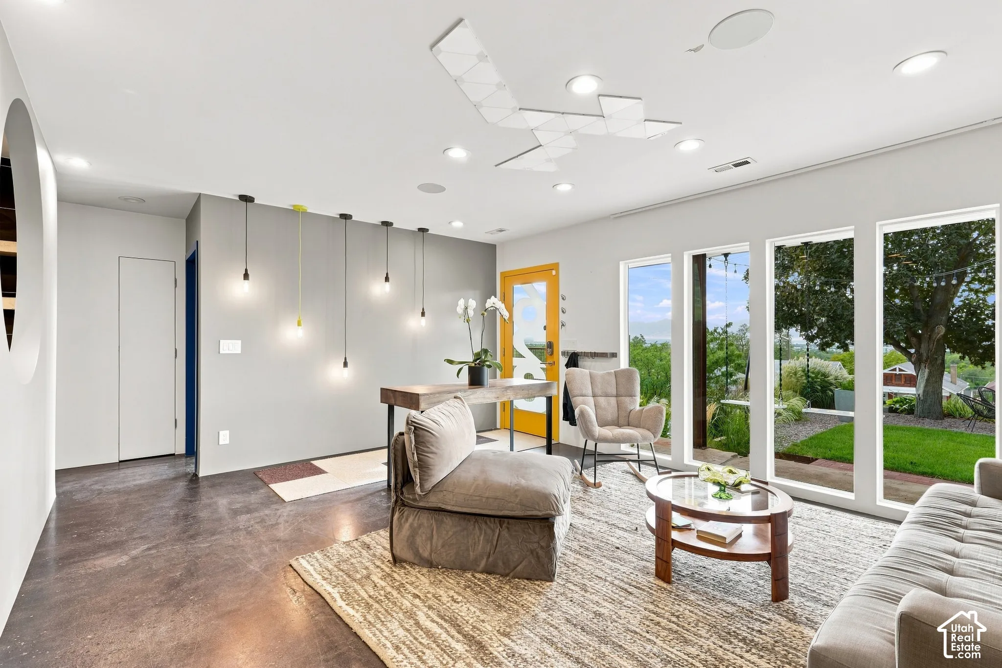 Polished concrete flooring with multiple pendant lighting fixtures and recessed ceiling lights