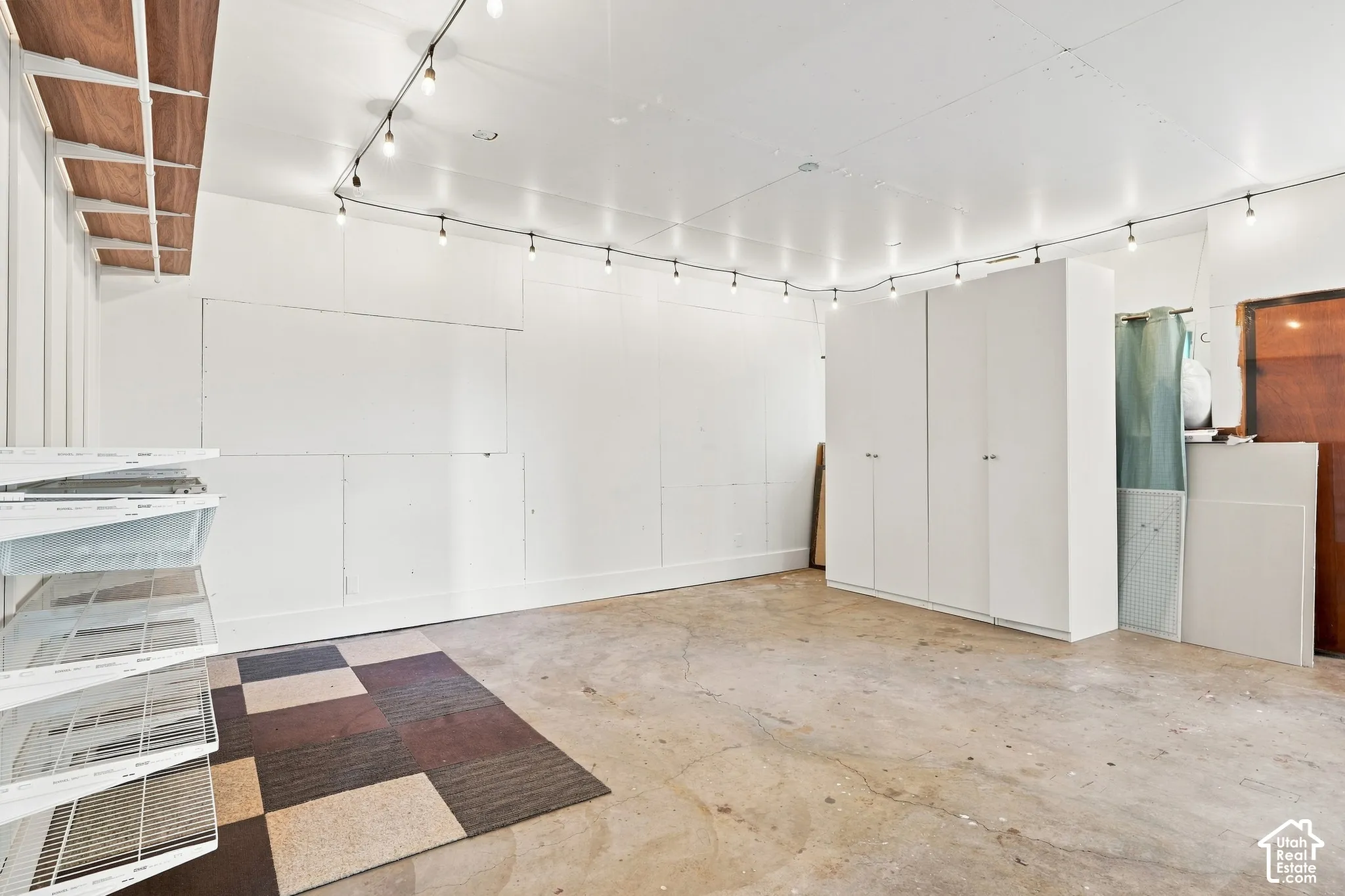 Concrete flooring and white walls with track lighting